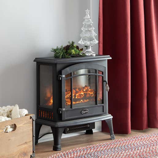 A glowing Panoramic Quartz Infrared Stove Heater sits in a living room