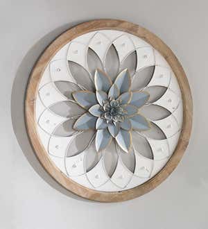 A round wall art medallion with a light blue flower motif and round wood frame.
