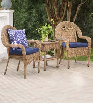 A pair of Prospect Hill wicker chairs with cushions and side table on a back deck.