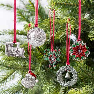 An assortment of pewter ornaments hung from pine boughs