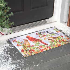 An embossed doormat with snowy cardinals on it